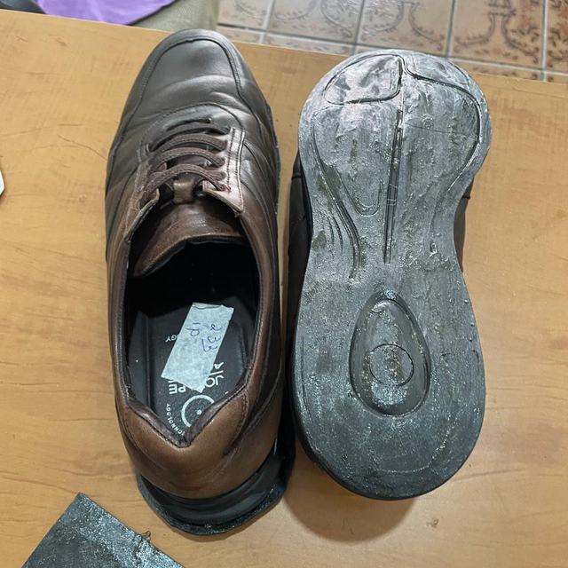 Sapato marrom e sola em conserto